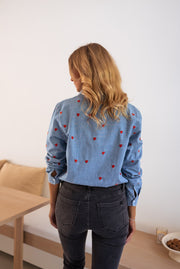 Chemise en jean à cœurs portée par une femme, vue de dos, sur un banc