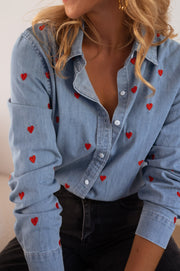 Chemise en jean à cœurs portée par une femme, vue rapprochée, petits cœurs brodés