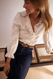 Chemise brodée à volants portée par une femme, vue rapprochée, manches à volants, ceinture
