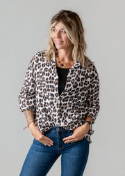 Chemise léopard en gaze portée par une femme, vue rapprochée, haut noir, mains dans les poches