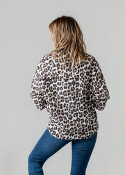 Chemise léopard en gaze portée par une femme, vue de dos, fond gris, jean