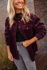 Chemise en velours ample bordeaux portée par une femme, vue rapprochée, sourire, jean gris