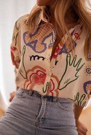 Chemise en coton à motifs portée par une femme, vue rapprochée, imprimé coloré, jean clair