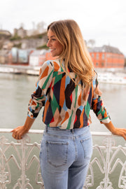 Chemise fluide à motifs multicolore portée par une femme, vue de dos, vue sur la ville, jean