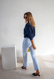 Chemise fluide en coton portée par une femme, vue de profil, jean clair, escarpins
