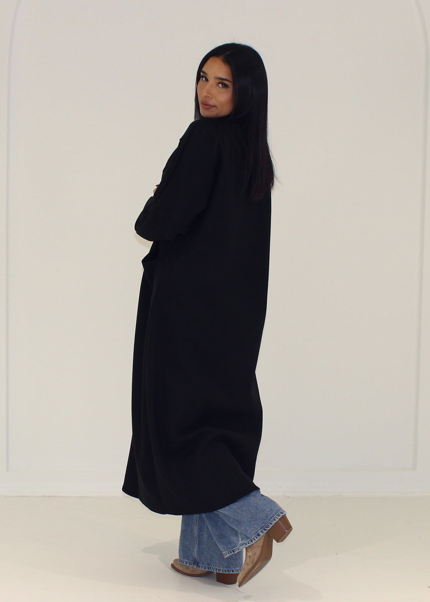 Manteau noir ample à poches — vue de dos.