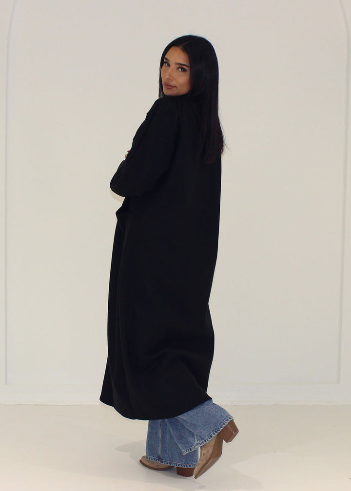 Manteau noir ample à poches — vue de dos.