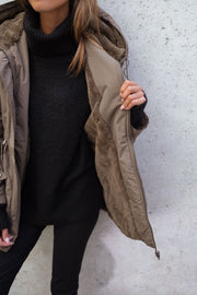 Manteau imperméable à capuche fourrée porté par une femme, vue rapprochée, manteau ouvert, doublure