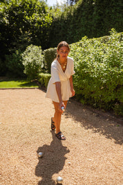 Combishort en gaze de coton porté par une femme, silhouette entière, allée, haie