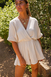 Combishort en gaze de coton porté par une femme, vue de trois-quarts, sourire, jardin