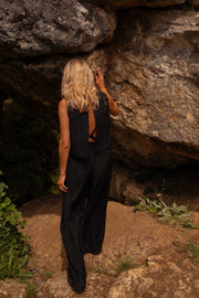 Combinaison brodée à dos ouvert portée par une femme, vue de dos, rocher, cheveux blonds