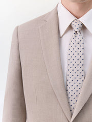 Costume 2 pièces beige — gros plan du revers, de la chemise et de la cravate