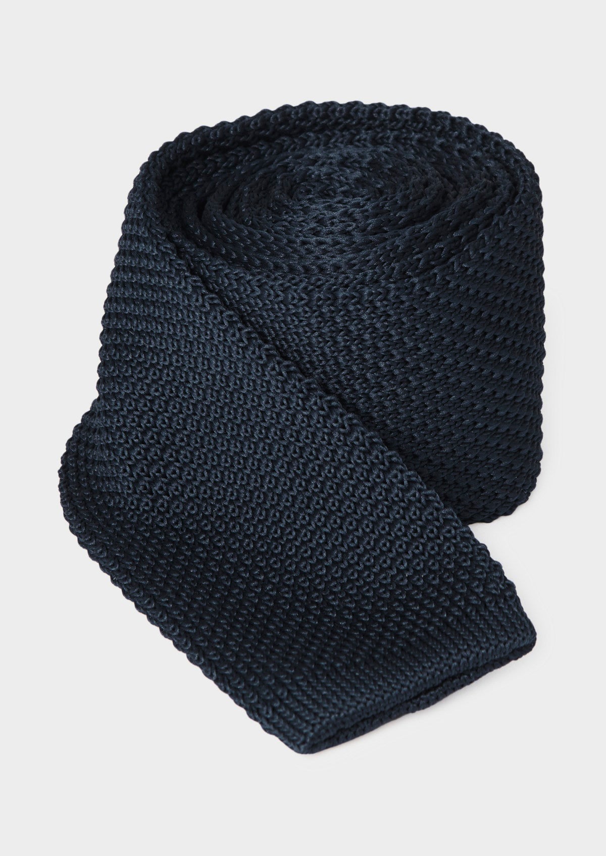 Cravate fine bleu nuit — pièce isolée, cravate roulée