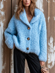 Cardigan bleu à col châle — vue portée de face, mains derrière la tête, pantalon noir