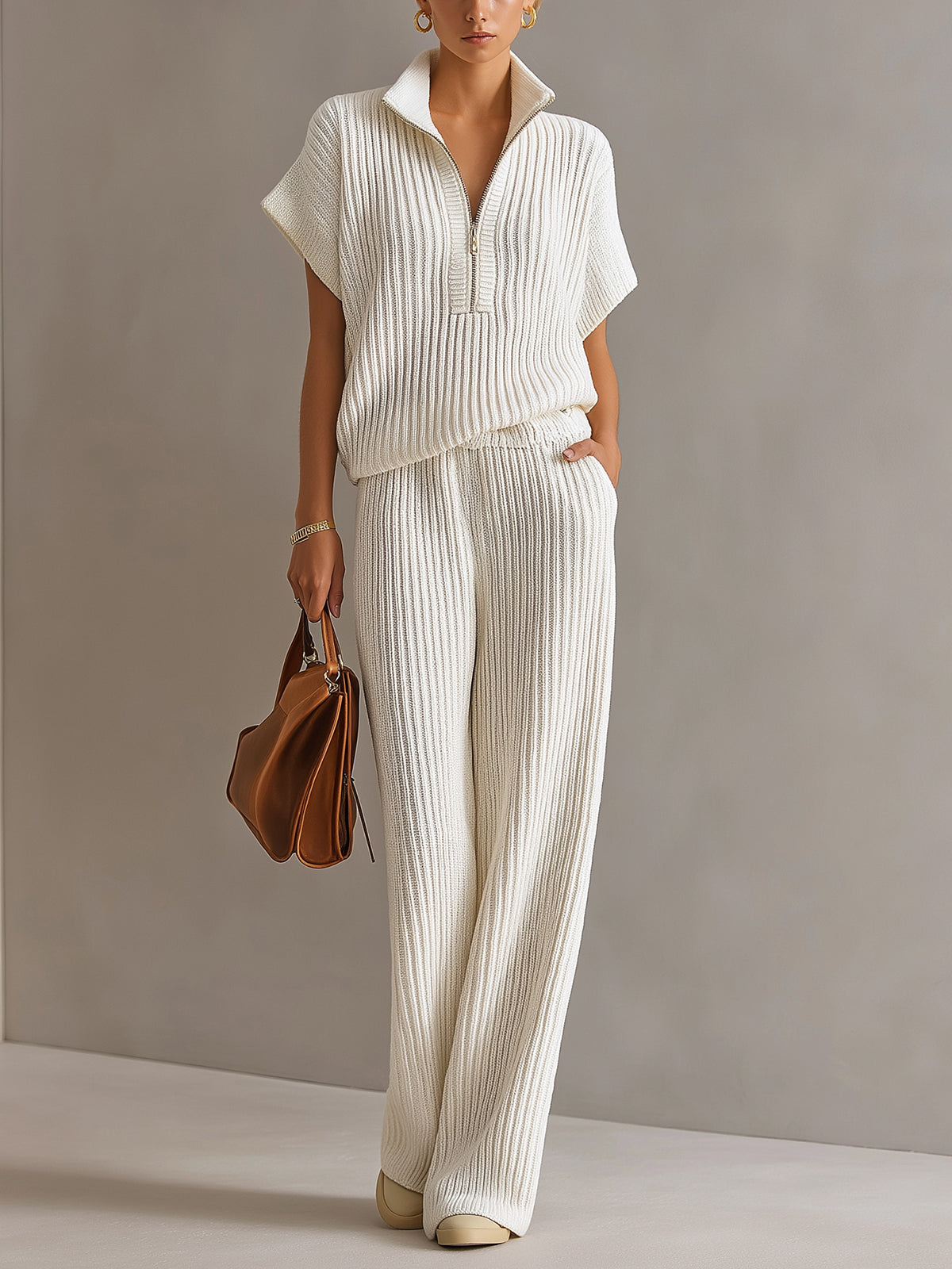 Ensemble côtelé col montant zippé crème — vue portée en pied, sac à main marron à la main