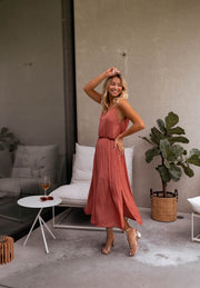Robe fluide effet soie fendue portée par une femme, vue de trois-quarts, plante, main sur la tête