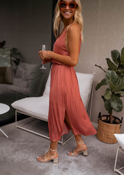 Robe fluide effet soie fendue portée par une femme, vue de face, plante verte, sandales