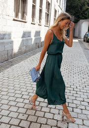Robe fluide effet soie portée par une femme, en marchant, ruelle, pochette bleue