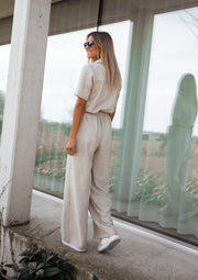 Combinaison fluide boutonnée portée par une femme, vue de dos, baie vitrée, pantalon large