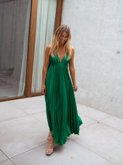 Robe plissée dos ouvert portée par une femme, vue de face, patio, cheveux blonds