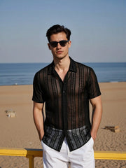 Chemise semi-transparente à manches courtes noir — vue portée de face, lunettes de soleil, en extérieur