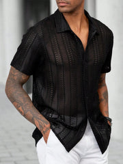 Chemise semi-transparente à manches courtes noir — vue portée de face, avec pantalon blanc