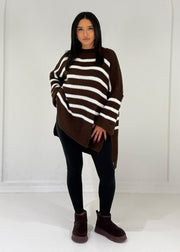 Pull rayé brun foncé — vue portée en pied, coupe asymétrique, legging noir et bottes bordeaux