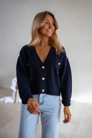 Gilet à boutons porté par une femme, vue rapprochée, sourire, jean clair
