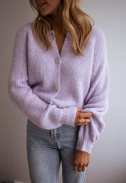Gilet à boutons fleuris brillants porté par une femme, vue rapprochée, jean clair, manches larges