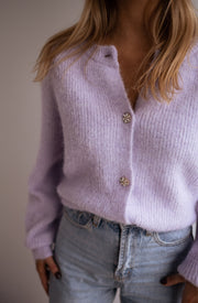 Gilet à boutons fleuris brillants porté par une femme, vue rapprochée, boutons brillants, jean clair
