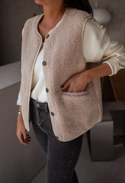 Gilet sans manches effet moumoute porté par une femme, vue de trois-quarts, mains dans les poches