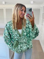 Gilet cache-cœur à paillettes porté par une femme, vue rapprochée, paillettes vertes, selfie