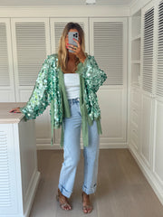 Gilet cache-cœur à paillettes porté par une femme, vue de face, selfie, ceinture nouée