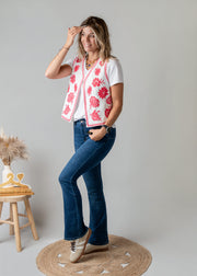 Gilet brodé floral sans manches porté par une femme, silhouette entière, jean flare, pose