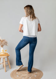 Gilet brodé floral sans manches porté par une femme, vue de dos, fond gris, t-shirt blanc