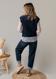 Ensemble gilet et chemise dentelle porté par une femme, vue de dos, gilet marine, jean
