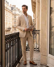 Costume 2 pièces beige — vue portée, appuyé à un balcon