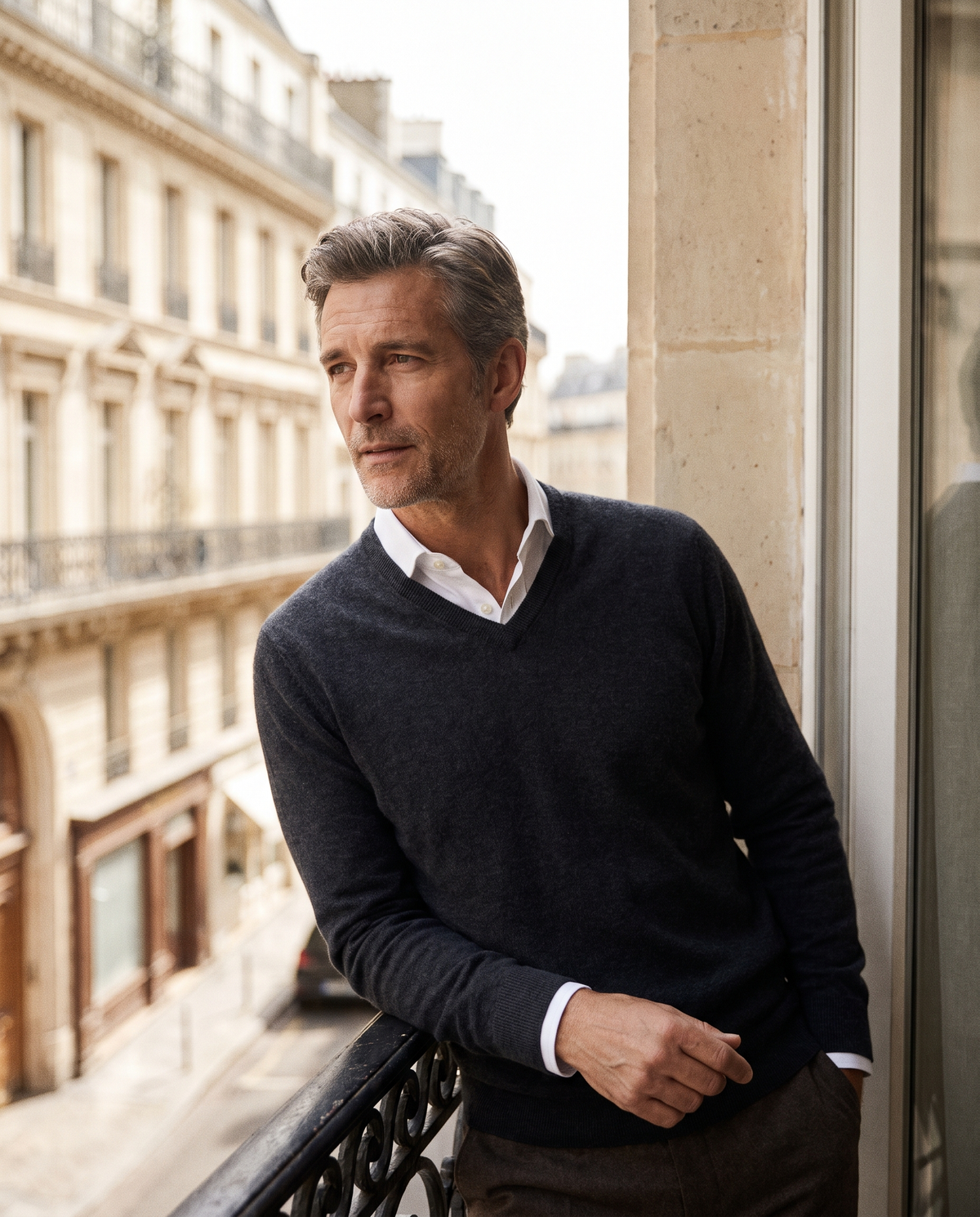 Pull essentiel col V marine — vue portée de face, sur un balcon