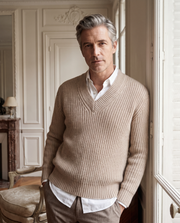 Pull Shetland col V beige — vue portée de face, adossé à une fenêtre