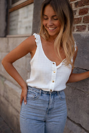 Top élastiqué à volants épaules porté par une femme, vue rapprochée, sourire, jean