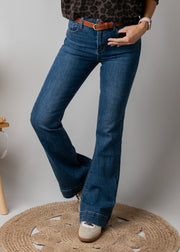 Jean flare en denim stretch porté par une femme, vue rapprochée, jean flare, ceinture marron