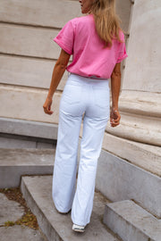 Jean évasé taille haute porté par une femme, vue de dos, colonne, t-shirt rose