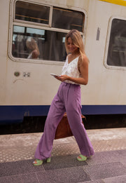 Pantalon en lin fluide porté par une femme, vue de trois-quarts, téléphone, train