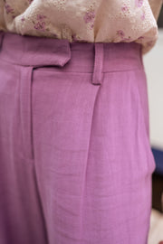 Pantalon en lin fluide porté par une femme, vue rapprochée, taille, passants