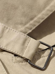 Détail d'une patte à boucle du manteau beige