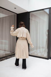 Trench ample ceinturé à poches porté par une femme, vue de dos, ceinture, de loin