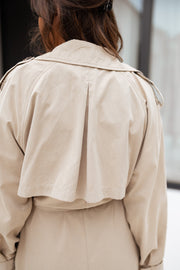 Trench ample ceinturé à poches porté par une femme, vue rapprochée, dos, martingale