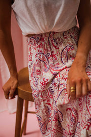 Jupe longue fluide à motifs portée par une femme, vue rapprochée, imprimé cachemire rose