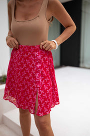 Jupe fleurie courte en lurex portée par une femme, vue rapprochée, fente, haut camel