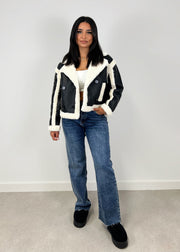 Veste similicuir noire — vue portée en pied, jean bleu et bottes noires